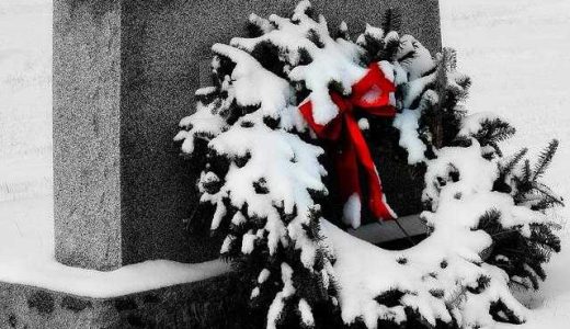 A snowy Christmas wreath as a decoration on the grave