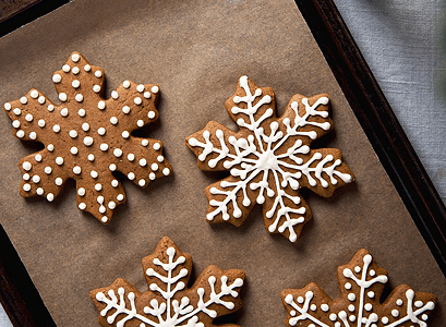 Decorated gingerbread cups in the shape of flakes on a sheet