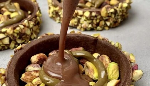 Cupcake with pistachios and chocolate frosting.