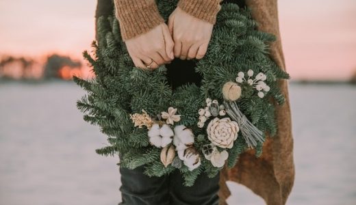 A girl holding a Christmas wreath made of fir branches