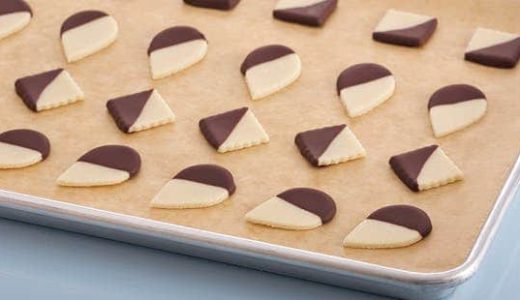 Marzipan sweets in the shape of drops and diamonds, half decorated with chocolate coating.
