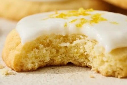 A cookie in the shape of a marigold with a lemon glaze