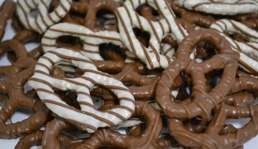 Chocolate pretzels on a plate, alternating chocolate decorations.