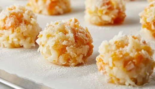Apricot balls with oatmeal on a white tray.