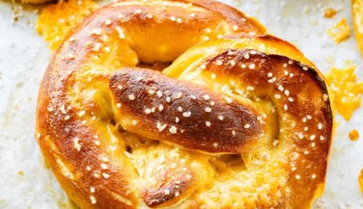 Stuffed pretzels on a baking sheet with dip.