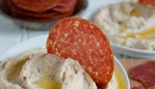 Cream spread on sandwiches with melted cheese and hard salami.