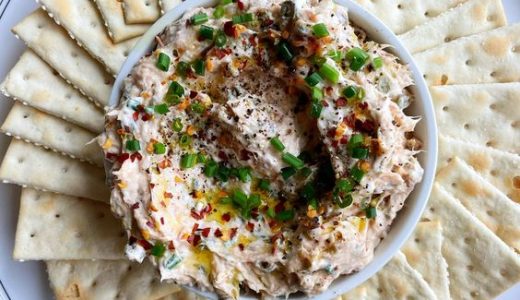 Spread with herbs, garlic and salami in a bowl with crackers.