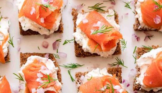Pieces of whole wheat bread with pieces of smoked salmon and dill.