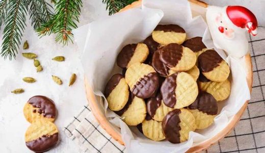 Christmas cookies dipped in chocolate coating in a bowl.