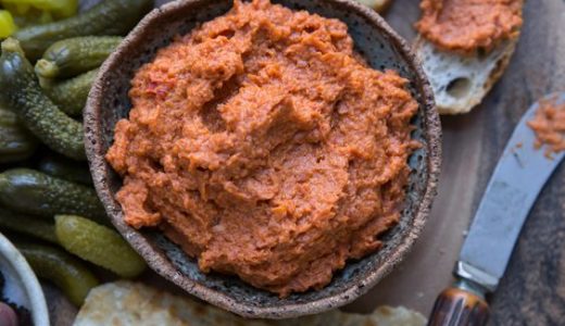 Bowl with salami spread and pickle.