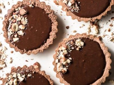 Short pastry filled to the brim with chocolate filling with nuts on top.