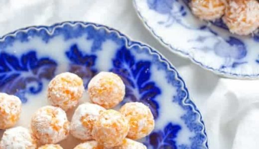 Coconut balls with apricots on plates.