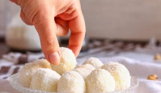 Raffaello marbles on a tray and a hand taking one marble.
