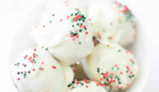 Nut balls in white chocolate with sprinkles in a bowl.