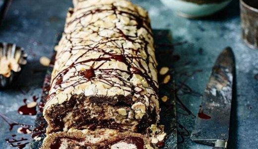 Meringue roll with chocolate and coffee with a knife next to it.