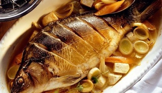 Whole baked carp on vegetables