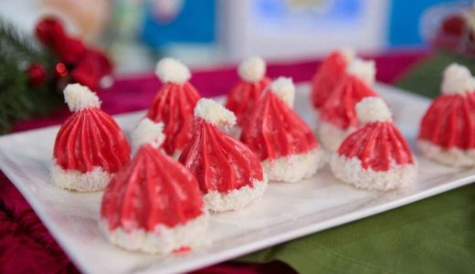 Christmas meringues in the shape of Santa Claus caps on a plate.