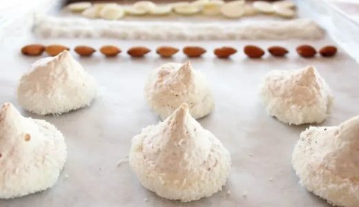 Meringues with homemade almond flour, dipped in white chocolate and covered in grated coconut.