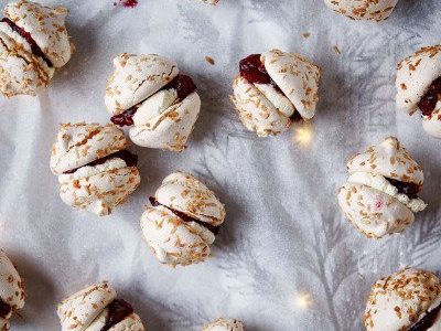 Snow meringues with coconut filled with fluffy whipped cream and cranberries.