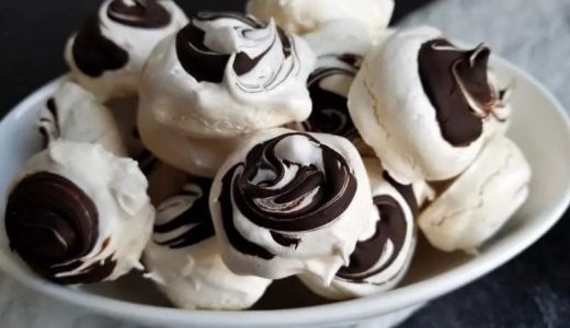 Meringue with chocolate swirls on a plate.